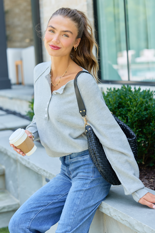 Model wearing grey Casey Henley pullover with blue jeans and a black shoulder bag