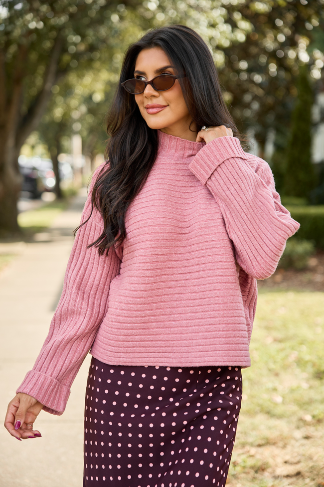 Front view, worn with a brown dotted skirt outdoors — mauve ribbed mock-neck sweater with wide sleeves.