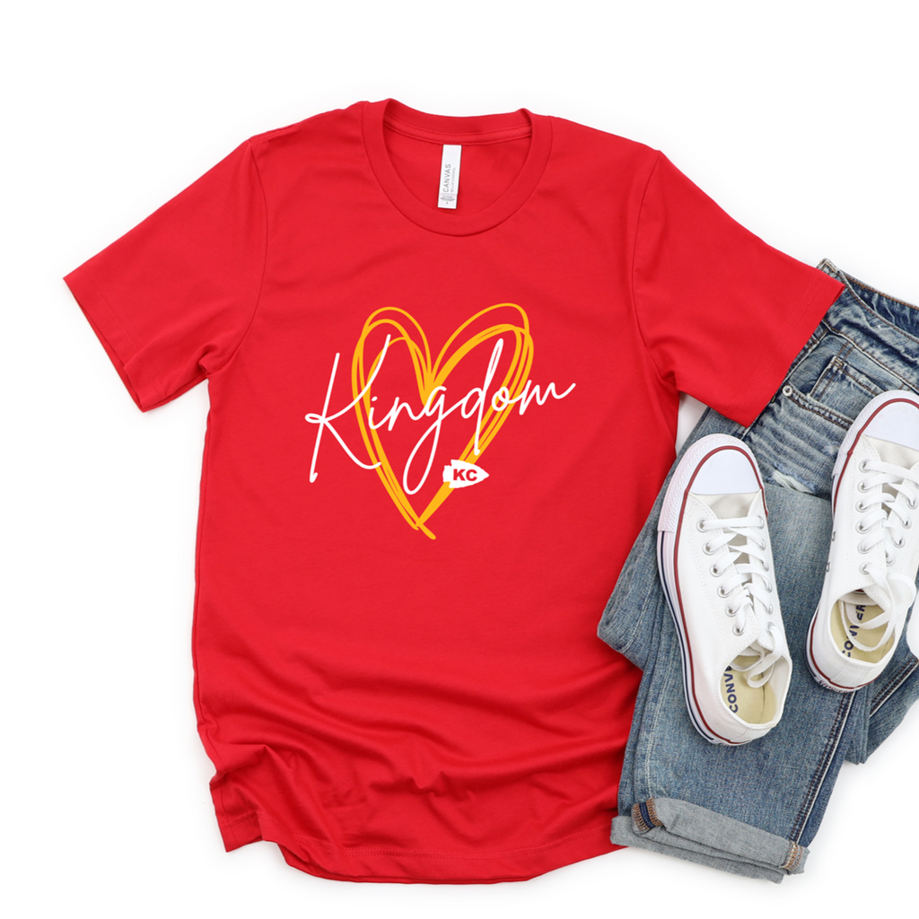 Red crewneck with white Kingdom script over a yellow scribble heart and small KC lettering.