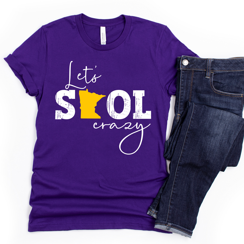 Model wearing a purple Let's Skol Crazy crewneck with white lettering and a yellow Minnesota silhouette.